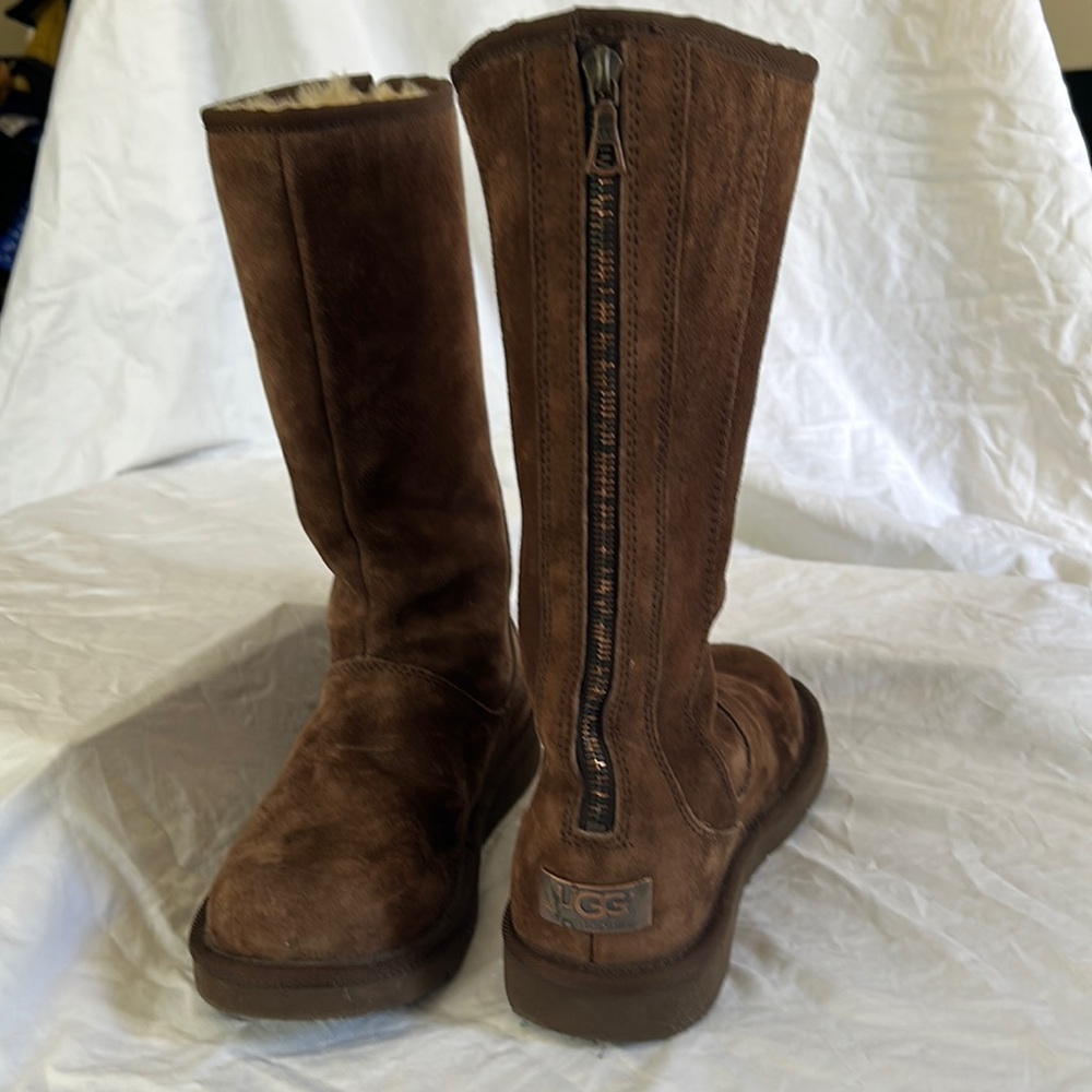 Tall UGG boot with back zipper. NEVER WORN!!  Brown/black zipper down back.